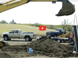 Image of a crane moving dirt with a pile of dirt